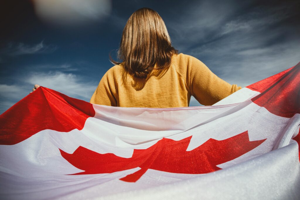 person holding a windswept canadian flag
