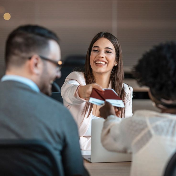 smiling people exchanging documents inside an office